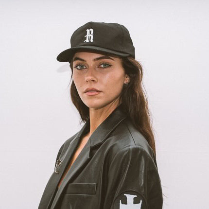 A woman wearing and showcasing Bernie Thomas x Rawninety Cap